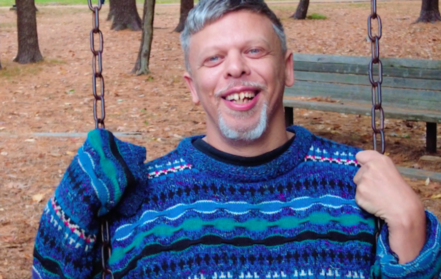 Ein Mann mit Williams-Beuren-Syndrom sitzt auf einer Schaukel